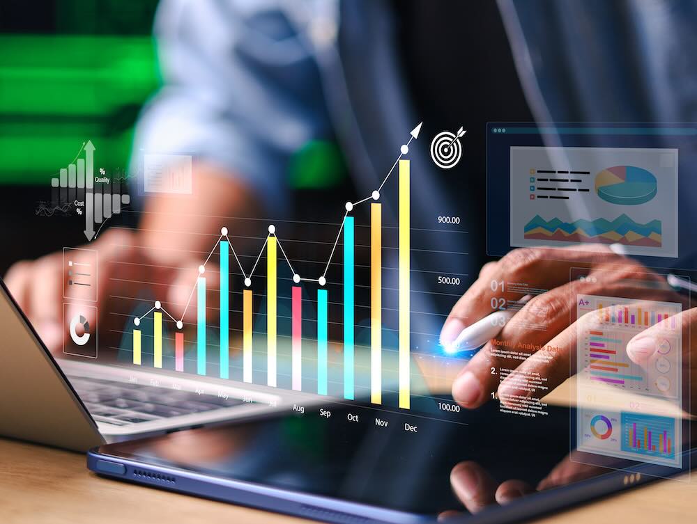 Investment data floating in front of a person who's working on a laptop
